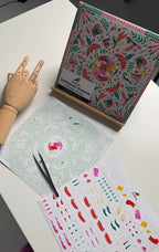 Colorful stationery items including a box, cards, and stickers on a white surface.