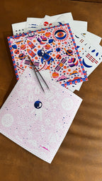 Colorful stationery items including a notebook and stickers on a wooden surface