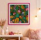 Colorful floral artwork in a pink frame on a wall with decorative items below.