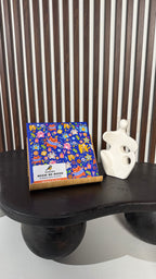 Colorful product packaging on a black surface with a striped background