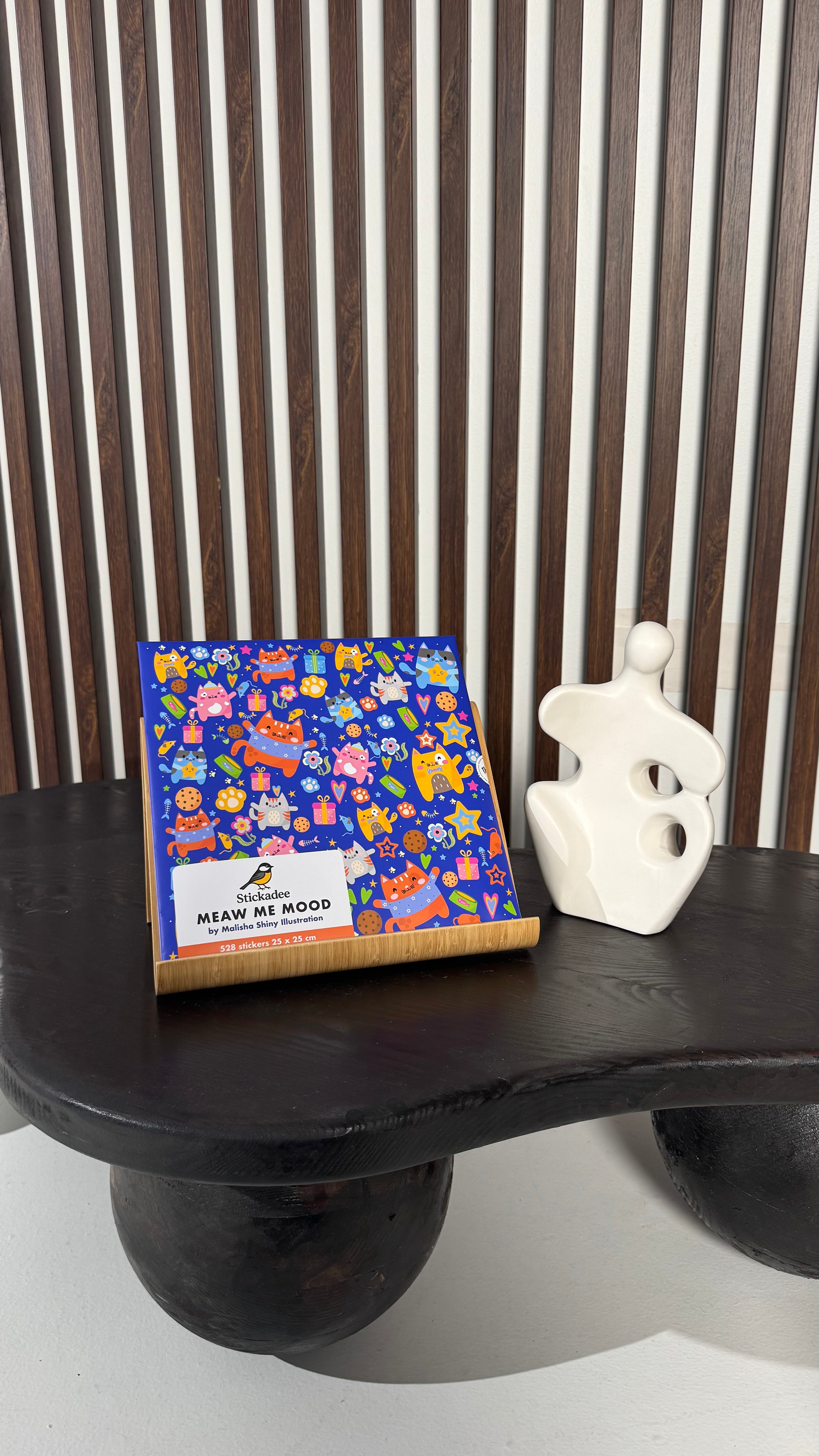 Colorful product packaging on a black surface with a striped background