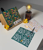 Sticker sheets with floral and animal patterns on a white surface with a lamp.